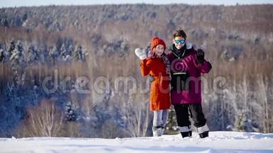 在<strong>阳光</strong>明媚的日子里，快乐的库普尔向山上滑雪场的摄像机挥手。 冬季，<strong>体育</strong>，假日，恋爱